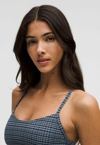 Top de bikini a cuadros azules con tirantes finos y escote cuadrado. Tejido suave con un patrón texturizado sutil. Diseño minimalista.