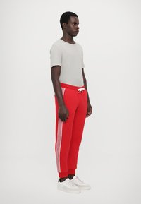 EA7 Emporio Armani PANTALONI - Treniņtērpa apakšdaļas - salsa