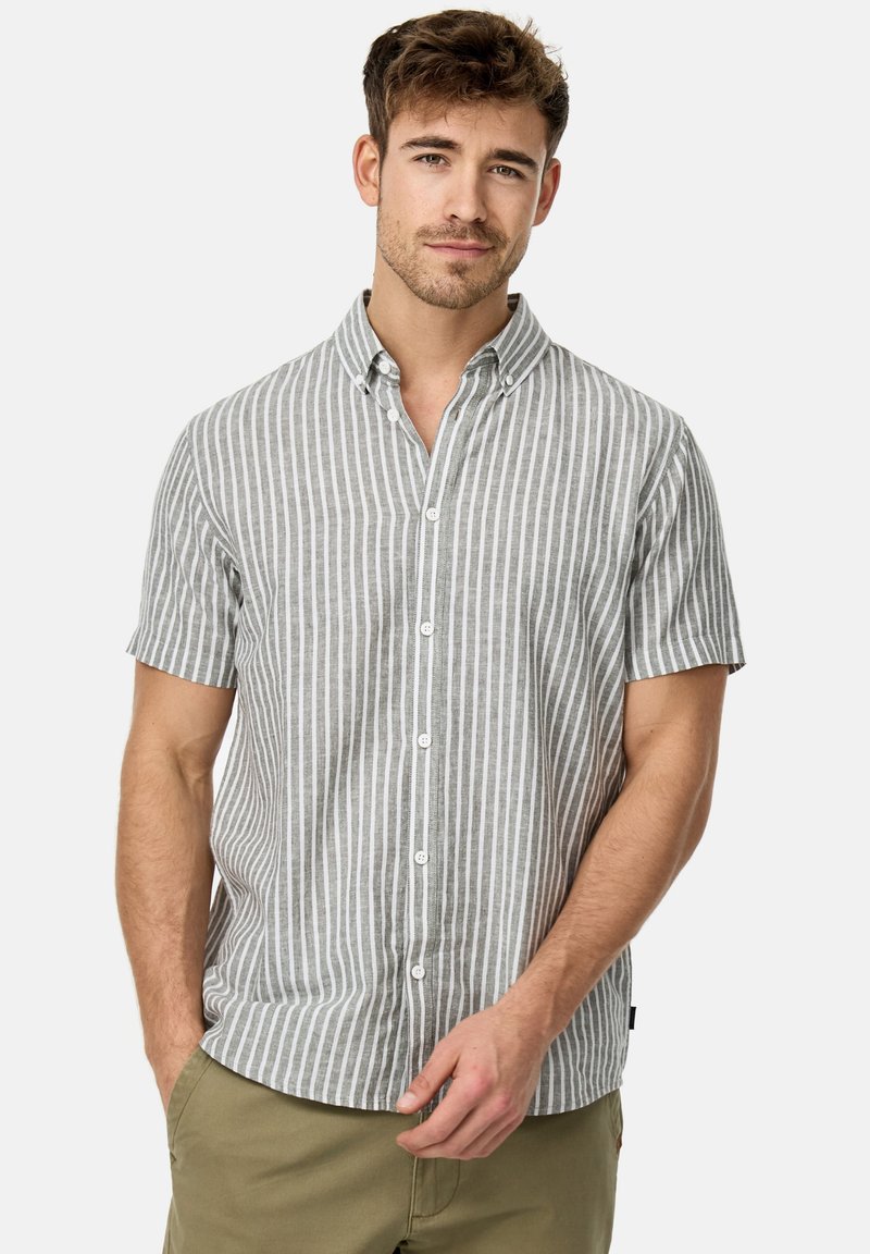 Camisa de botones de manga corta en gris claro con rayas verticales blancas. Presenta un cuello y una textura de tela suave. Diseño ajustado.