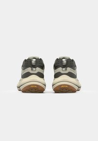 Two athletic shoes with a grey and cream color scheme. Features a padded collar, Vibram sole, and a textured rubber outsole.