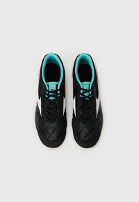Zapatillas deportivas negras con textura acolchada, acentos blancos y forro turquesa. Presentan un diseño de cordones y punta redondeada.