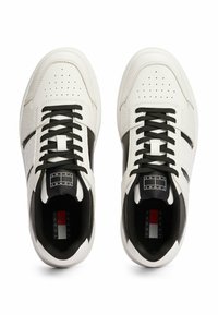 Witte leren sneakers met zwarte accenten, perforaties en platte zwarte veters. Heeft rubberen zolen en een logolabel op de tong.