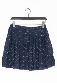 Marinblå plisserad kjol med vitt stjärnmönster, tillverkad av lätt material. Har en midjeresår och en liten dekorativ stjärndetalj.