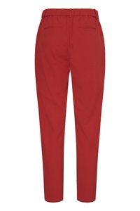 Rode taps toelopende broek met elastische tailleband en twee achterste paspelzakken, getoond van achteren op een witte achtergrond.