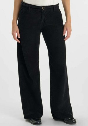 Zwarte corduroy broek met een wijd pijpenontwerp, voorzien van een knoopsluiting en riemlussen. De stof heeft een ribbelstructuur en een gladde afwerking.