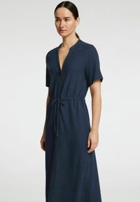 Robe bleu marine, midi, avec des manches courtes, un décolleté en V profond et une ceinture à la taille. Fabriquée en tissu doux avec une coupe décontractée et sans motifs visibles.