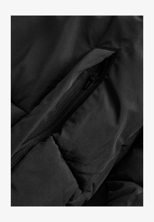 Schwarze Winterjacke mit Details wie einer Reißverschlusstasche, die mit einem strukturierten Stoff und weichen, gepolsterten Bereichen um den Reißverschluss versehen ist.