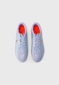 Vaaleansiniset jalkapallosukat, joissa on teksturoitu pinta, oranssit yksityiskohdat ja musta Nike-logo. Varustettu nauhakiinnityksellä ja pehmeillä pohjilla.