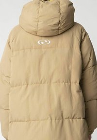 Tan puffer jacket with a hood, featuring quilted panels and a white logo on the back. The material appears smooth with a slightly shiny finish.