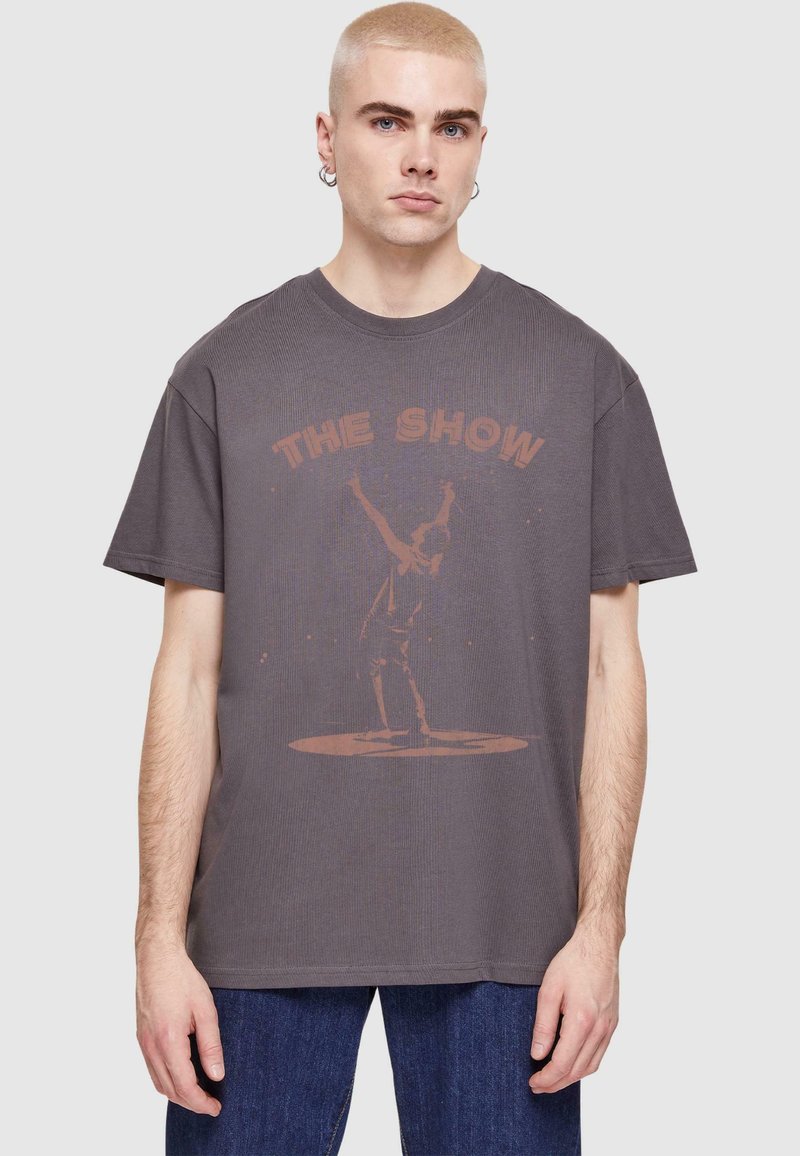 Szara bawełniana koszulka z krótkim rękawem, z wyblakłym nadrukiem graficznym przedstawiającym wykonawcę oraz napisem "THE SHOW" w kolorze rdzy.