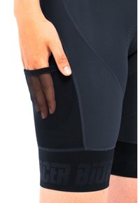 Black cycling shorts made from smooth, stretchy material featuring a mesh side pocket, contrasting textured waistband, and flatlock seams.