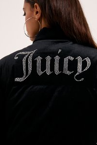 Crni baršunasti sako s velikim logotipom "Juicy" ukrašenim rhinestonesima na leđima u bogatom fontu. Glatka tekstura, opušteni kroj.