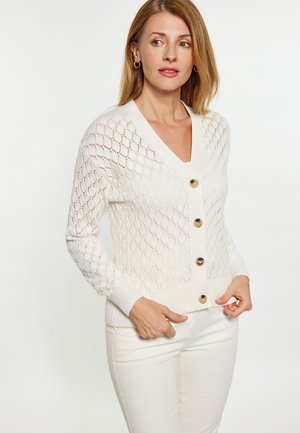 Witte gebreide cardigan met diamantpatroon, V-hals, lange mouwen en grote beige knopen. Materiaal lijkt zacht en textuur te hebben.
