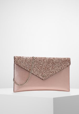 Clutch-Tasche in Roségold mit glitzerndem Umschlagklappe und silberner Kettenriemen, platziert auf einer weißen Ausstellungsfläche vor einem hellgrauen Hintergrund.