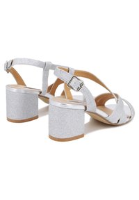 Sandali con tacco a blocco largo in glitter argento, con cinturino alla caviglia regolabile, design con punta aperta e fasce incrociate per una vestibilità sicura.