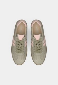 Αθλητικά παπούτσια σε ελιά πράσινο με ανοιχτό ροζ λεπτομέρειες. Υλικό από σουέντ, στρογγυλή μύτη, επίπεδες κορδόνια, δύο οριζόντιες ρίγες στις πλευρές και λαστιχένια σόλα.