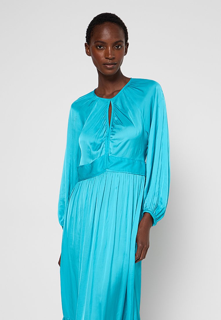 Türkises Langarmkleid mit Schlüsselloch-Ausschnitt, plissiertem Oberteil und elastischen Bündchen, aus glattem Satinmaterial gefertigt.