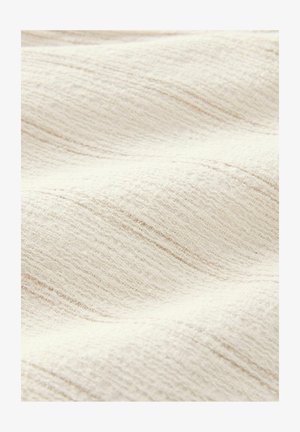 Struktureret, off-white stof med et subtilt bølgemønster. Overfladen fremstår blød og har fine, ujævne linjer for yderligere dybde.