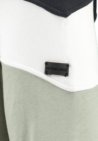 Felpa a blocchi di colore con pannelli nero, bianco e verde chiaro. Presenta un'etichetta logo nera cucita sul davanti. Tessuto morbido in cotone.