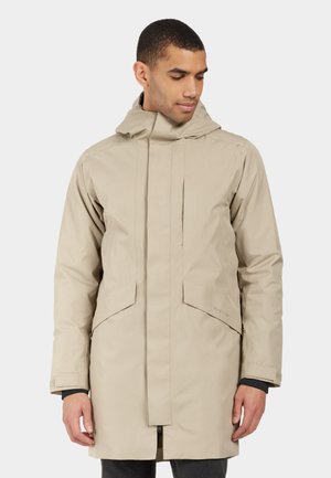 Beige wasserdichte Parka mit Kapuze, ausgestattet mit einem Frontreißverschluss, zwei großen Taschen und einem lockeren Schnitt. Glatte Textur und einfaches Design.