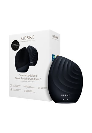 Brosse faciale sonique noire GESKE avec surface texturée à côté d’une boîte blanche indiquant le nom du produit et ses fonctionnalités pour un nettoyage en profondeur et un massage.