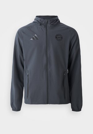 Chaqueta de color gris oscuro con cremallera y capucha, diseñada con tejido ligero, puños elásticos y bolsillos laterales. Presenta los logos de Adidas y Bayern Múnich.
