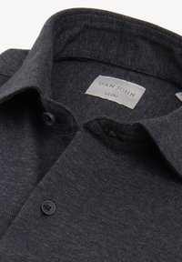 Mørkegrå, slim-fit skjorte med krave og knapper samt et synligt "Dan John"-mærke indeni kraven.