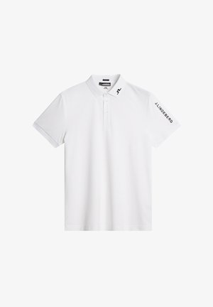Biała koszulka polo wykonana z gładkiego materiału, z kołnierzykiem, trzema guzikami z przodu oraz czarnym logo na ramieniu.