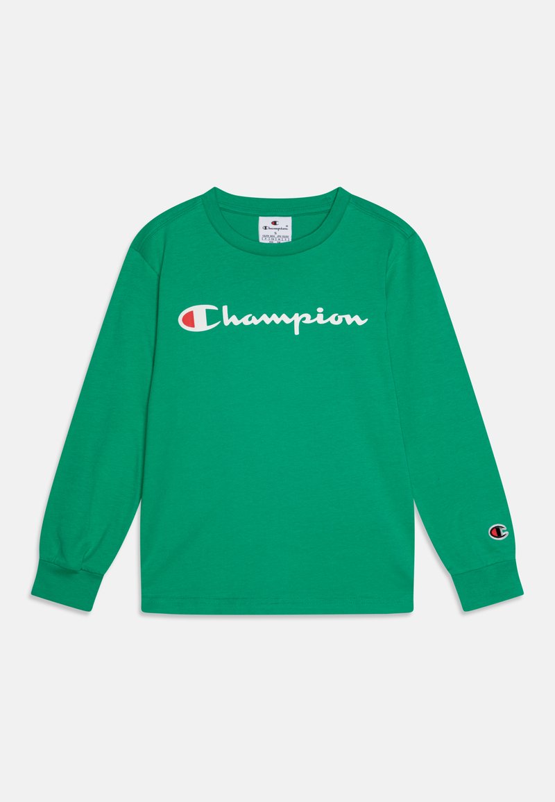 Roheline pika varrukaga T-särk, mis on valmistatud puuvillast. Ees on valge "Champion" logo ja vasakul varrukal on väike logopaik.