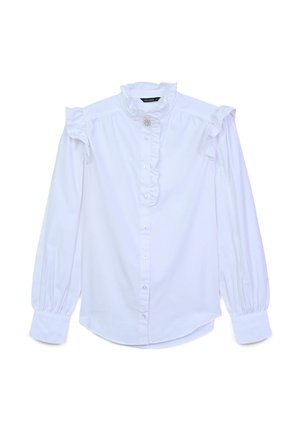 White cotton blouse with ruffled shoulders, high neck, and button closure. Features long sleeves with gathered cuffs and front ruffle detail.