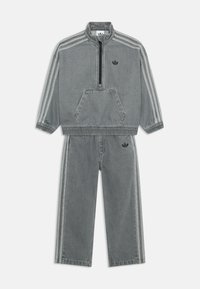 Tuta in denim grigio con pullover a mezza zip e tasca a marsupio, dotato di polsini elasticizzati, abbinato a pantaloni coordinati con strisce a contrasto.