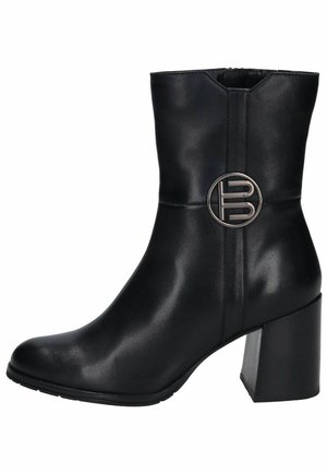 Stivaletto in pelle nera con punta rotonda, tacco a blocco e accento in metallo circolare lato. Texture liscia e design elegante.