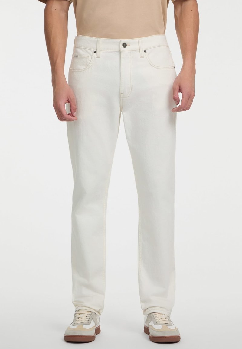 Beli jeans z ravnim krojem, z mestnimi žepki in subtilnim šivom. V kombinaciji s bež superge za kontrast.