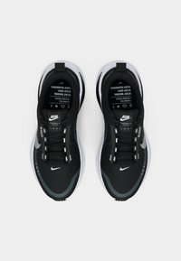 Een paar zwart-witte Nike hardloopschoenen met Gore-Tex, van bovenaf gezien op een witte achtergrond.