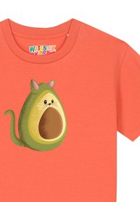 T-shirt corail avec un design de chat-avocat en cartoon, comportant une graine marron, des accents verts et des moustaches subtiles, imprimé sur un tissu doux.