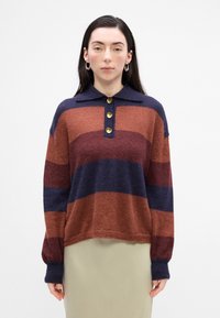 Pull en tricot avec un col, présentant de larges rayures horizontalement dans des teintes de rouille, bourgogne et marine, et trois boutons dorés comme détails.