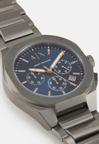 Orologio cronografo in acciaio inox con quadrante ottagonale, dial blu navy, dettagli in oro rosa e bracciale a maglie; display della data alle 4 o'clock.
