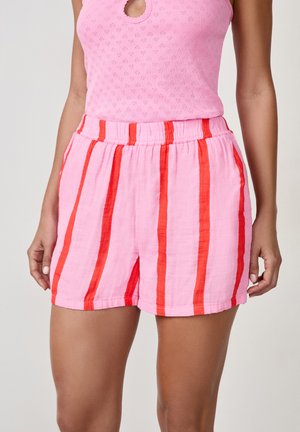 Roze shorts met gedurfde verticale rode strepen, voorzien van een elastische tailleband en een relaxte pasvorm. Gemaakt van lichtgewicht stof.
