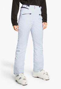 Helle blaue Skihosen mit hoher Taille, zwei Reißverschlusstaschen und Knopfdetails. Glatte Textur mit einem Logo auf dem linken Oberschenkel.