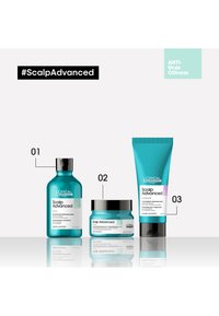 Tre hårvårdsprodukter: en teal schampo-flaska, en teal burk med svart lock och en teal tub, alla märkta "Scalp Advanced" för hårbottenvård.