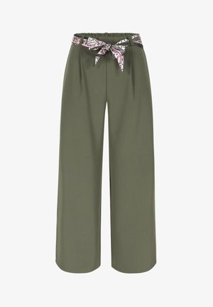 Olivzaļas krāsas plata piegriezuma bikses ar savākto jostasvietu un violets rakstains auduma josta ar mezglu.