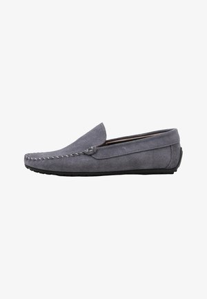 Mocasín de hombre de ante gris con costuras estilo mocasín, suela de perfil bajo y diseño sin cordones.