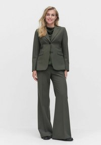 Dunkelgrüner Blazer und weit geschnittene Hose aus glattem Stoff, mit einem Einzelknopfverschluss, taillierter Passform und vorderen Taschen.