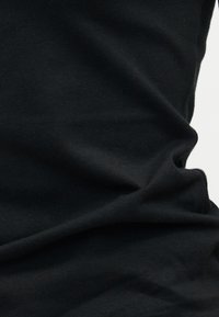 Tissu noir avec des plis doux et une surface légèrement texturée, éclairé de manière uniforme avec des ombres minimales sur un fond neutre.