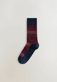 Chaussette marine unique avec un motif rayé horizontal rouge et rose sur la jambe et le pied, sur fond clair.
