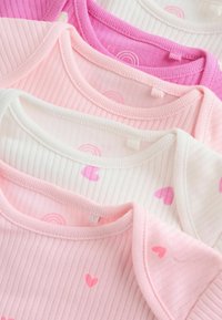 Quattro body per neonati in cotone, di colore rosa e bianco, con trama a coste e motivi di cuori e arcobaleni. Collo regolabile visibile.