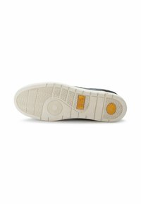 Sneaker-Sohle aus weißem Gummi mit einem gewellten Profil. Verfügt über ein gelbes Logo und kreisförmige Details an der Unterseite für besseren Halt.
