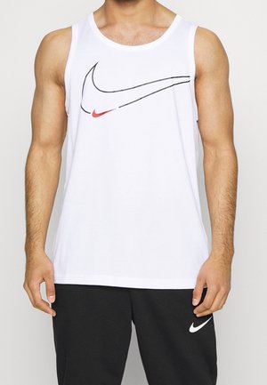 Mężczyzna w białej koszulce bez rękawów z dużym czarno-czerwonym logo swoosh i czarnych spodniach z białym logo swoosh.