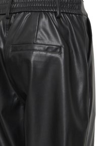 Pantalon noir en simili cuir avec poche arrière passepoilée et poche latérale, taille élastique avec passants de ceinture et texture lisse et brillante.