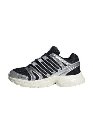 Chaussure de sport noire et argentée avec une tige en maille structurée, des accents réfléchissants, une semelle amortie et un design élégant et arrondi.